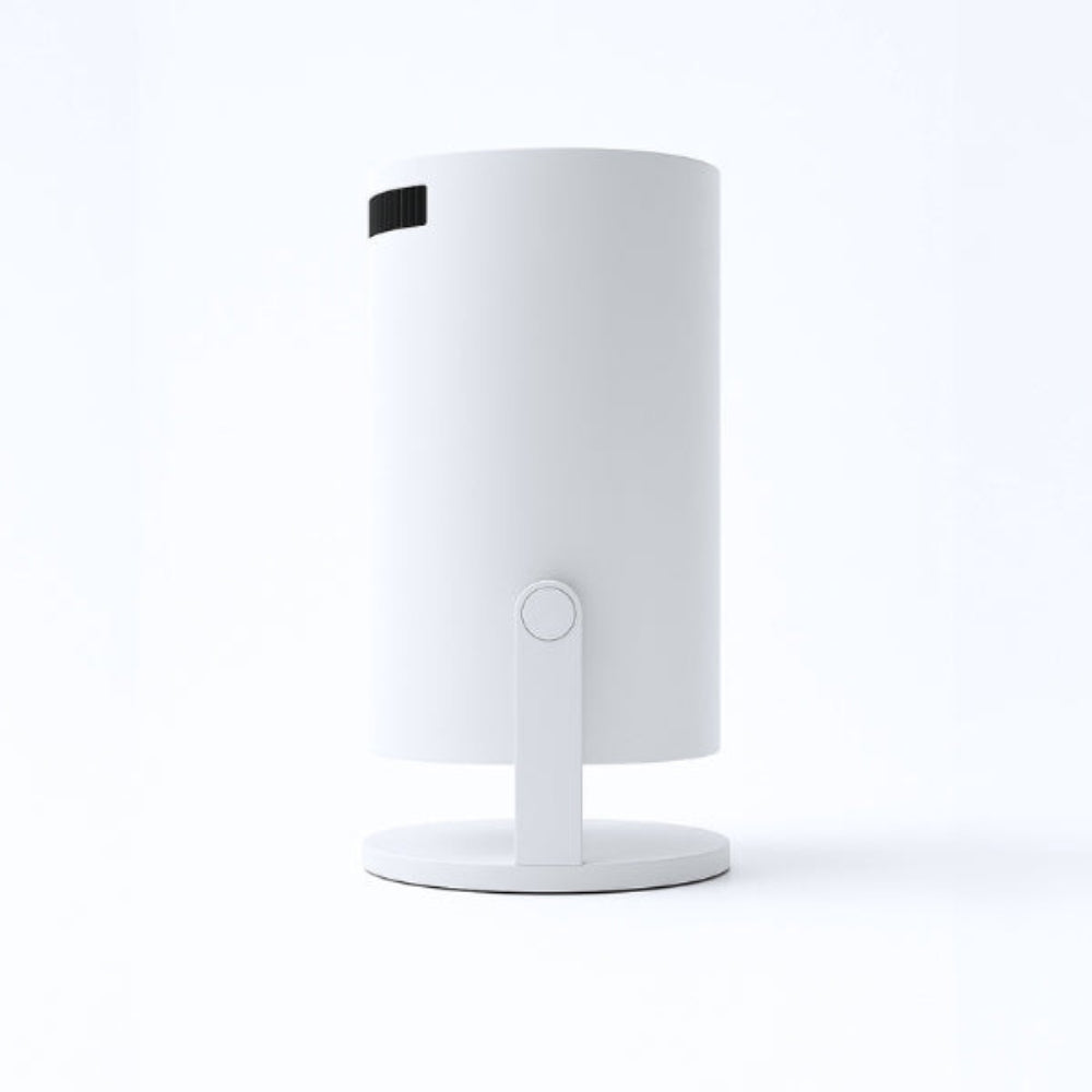 The Spotlight Projector by The Projection Room is a modern cylindrical white device with a small vent near the top, offering wireless streaming. It mounts on a round base with a single vertical support, shown against a plain white background.