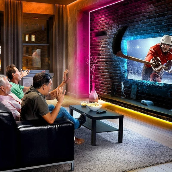 Three men on a couch watch a 3D hockey game as vibrant RGB lights from The Projection Rooms USB LED Light Strips (1M, Smart Control) create an immersive glow in their modern living room.