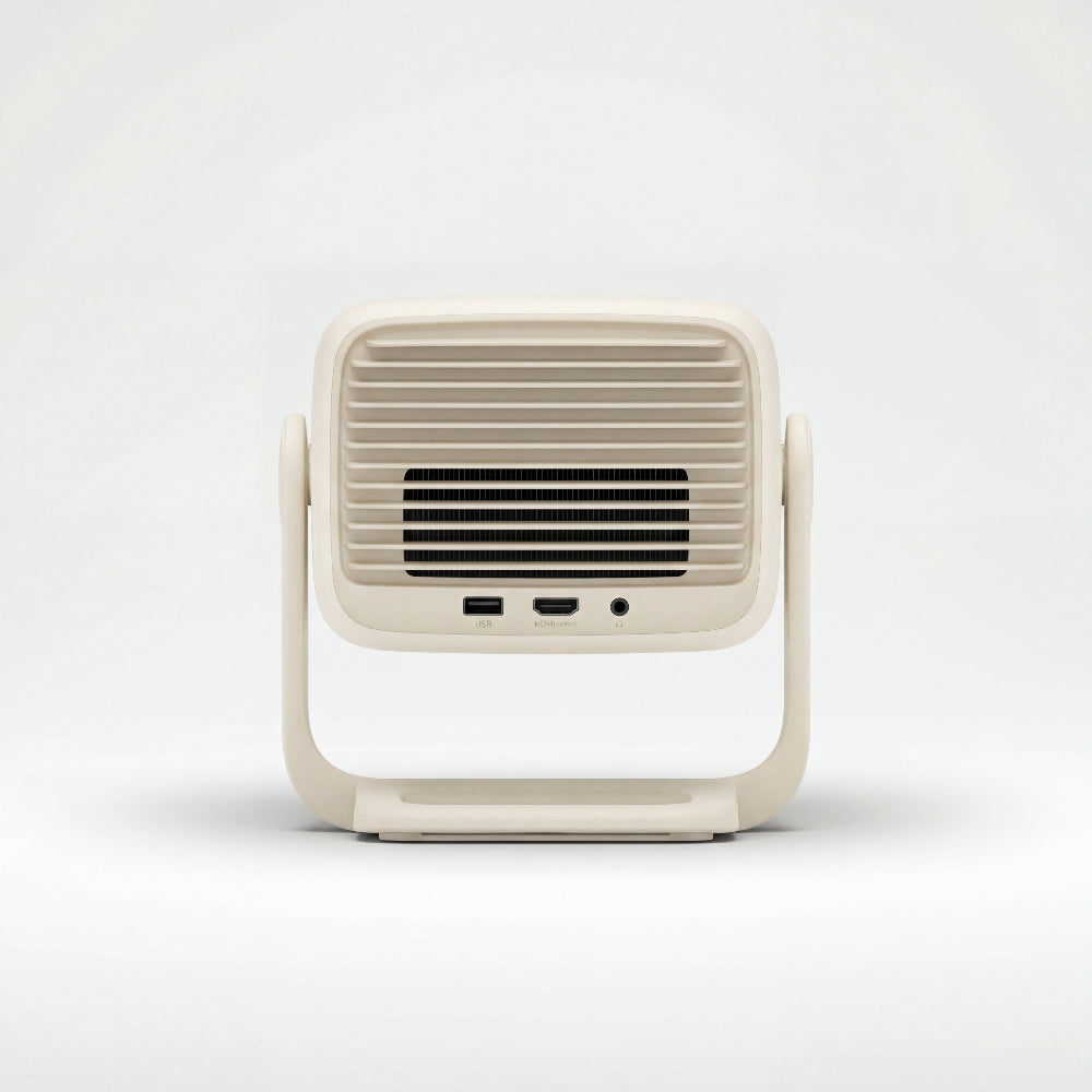The JMGO N1S Nano by JMGO is a beige rectangular device with a vented front grill, USB and audio ports at the bottom, and a U-shaped stand—ideal for enjoying Dolby Audio on the big screen.